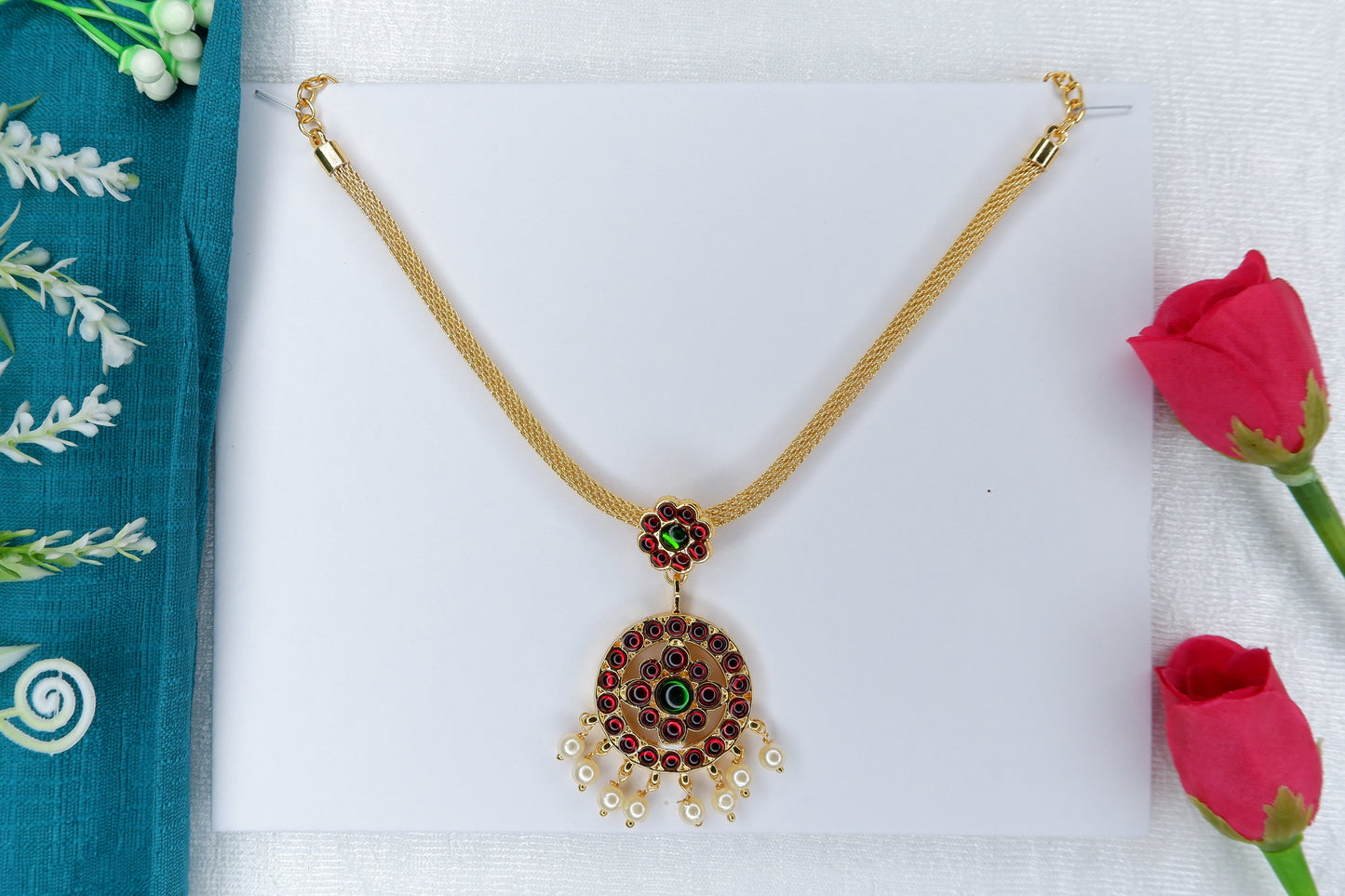 Short Indian classical dance necklace featuring gold-toned temple-style work with red and green stones, worn as part of Bharatanatyam and Kuchipudi dance ornaments.
