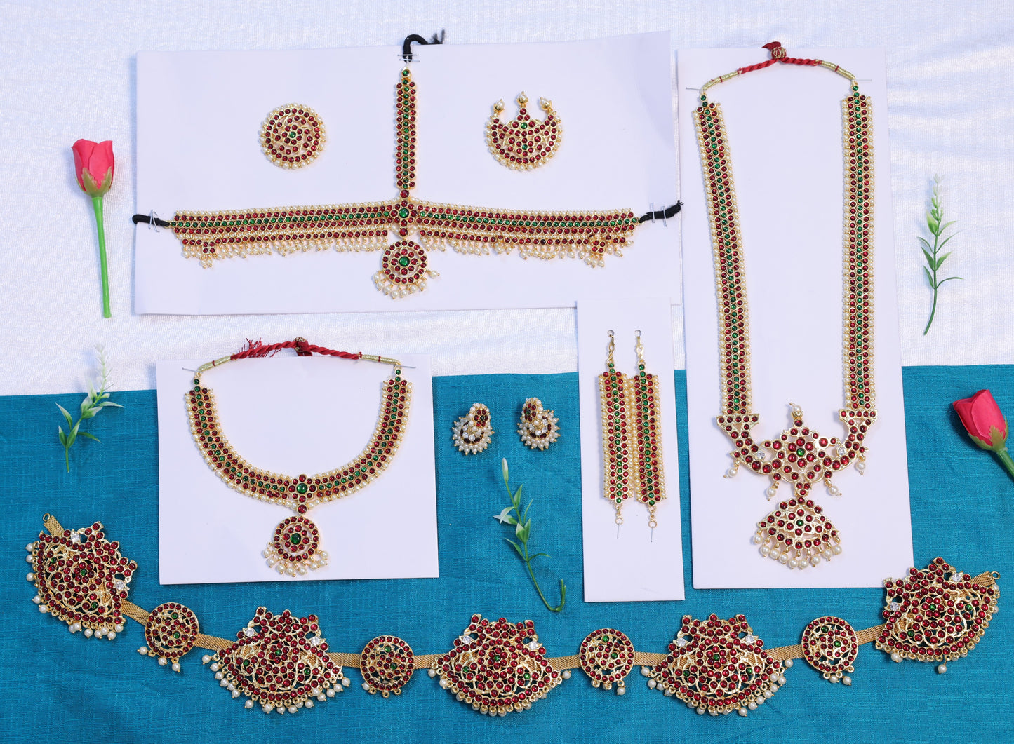 Classical Indian dance jewellery set for Bharatanatyam and Kuchipudi including necklaces, earrings, and waist belt laid out on white and blue cloth