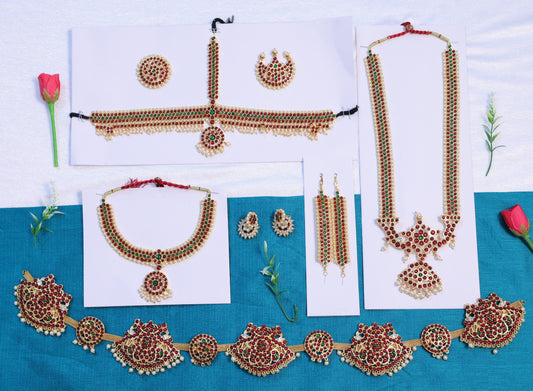 Classical Indian dance jewellery set for Bharatanatyam and Kuchipudi including necklaces, earrings, and waist belt laid out on white and blue cloth