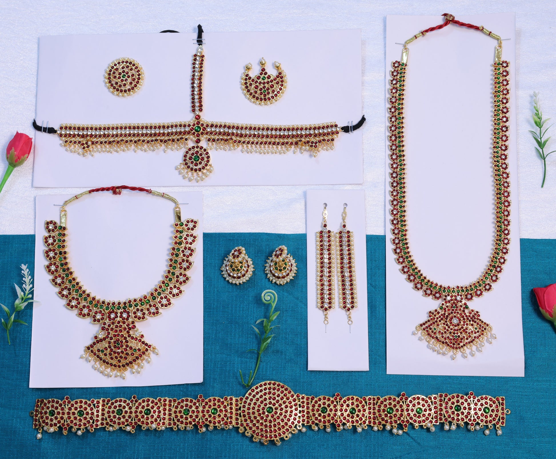 Indian bridal temple jewelry set with gold-plated red and green stone necklaces, waist belt, earrings, and maang tikka — displayed for product listing in USA