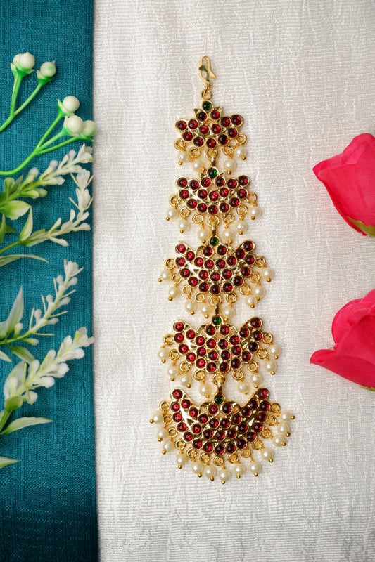 raditional Bharatanatyam dancer wearing ornate gold mang tika with temple jewelry set.