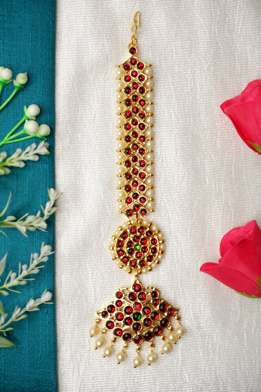Bharatanatyam jewelry set highlighting the elegant mang tika with pearls and red stones